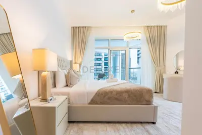 a white bedroom with a bed and a large window at Marina Canal View Apartment, Walking Distance to The Metro and Tram, Near The Beach and Top Dining - Bayside Residence, Dubai Marina by Deluxe Holiday Homes in Dubai