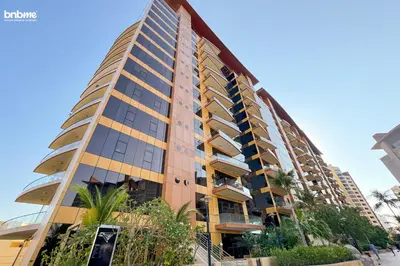 a tall building with palm trees in front of it at bnbmehomes - Tiara Residence in Dubai