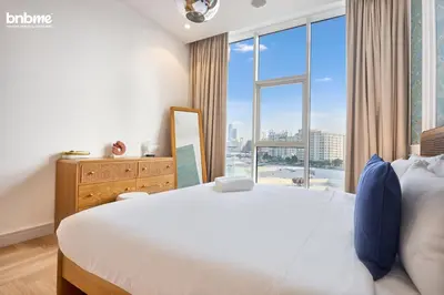 a bedroom with a large bed and a large window at bnbmehomes - Tiara Residence in Dubai