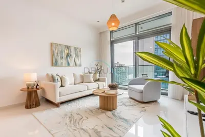 a living room with a white couch and a large window at Prime Waterfront Location with Stunning Palm Jumeirah Views, Close to Dubai Top Attractions - Beach Vista Tower 2, Emaar Beachfront by Deluxe Holiday Homes in Dubai