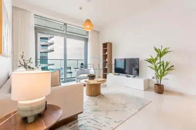 a living room with a couch and a tv at Prime Waterfront Location with Stunning Palm Jumeirah Views, Close to Dubai Top Attractions - Beach Vista Tower 2, Emaar Beachfront by Deluxe Holiday Homes in Dubai