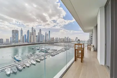 a balcony with a view of a harbor with boats at Elegant Beachfront 2BR at Palace Beach Residence in Dubai