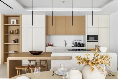 a kitchen with white cabinets and a table and chairs at Upscale City Walk 3BR plus Maid Near Dubai Mall in Dubai