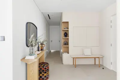 a hallway with a mirror and a table and a chair at Upscale City Walk 3BR plus Maid Near Dubai Mall in Dubai
