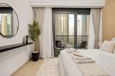 a hotel room with a bed and a large window at Stunning 2BR with Full Burj View in the Opera District in Dubai
