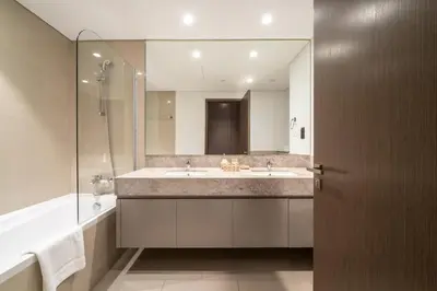 a bathroom with a sink and a large mirror at Stunning 2BR with Full Burj View in the Opera District in Dubai
