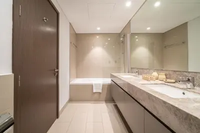 a bathroom with two sinks and a tub and a mirror at Stunning 2BR with Full Burj View in the Opera District in Dubai
