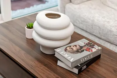 a vase and a book on a coffee table at Chic 1BR at Reva Stunning Canal Views in Dubai