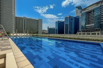 a large blue swimming pool on top of a building at Chic 1BR at Reva Stunning Canal Views in Dubai