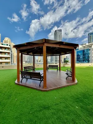a gazebo with benches on a green field at The Urban Retreat in Dubai