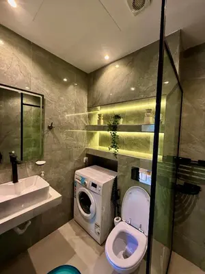 a bathroom with a toilet and a sink and a washing machine at The Urban Retreat in Dubai