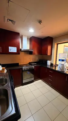 a kitchen with wooden cabinets and a sink in it at 1 Bhk with open terrace in Dubai
