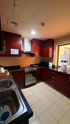 a kitchen with wooden cabinets and a sink in it at 1 Bhk with open terrace in Dubai