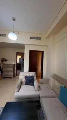 a living room with a couch and a table at 1 Bhk with open terrace in Dubai
