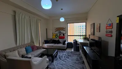 a living room with a couch and a tv at 1 Bhk with open terrace in Dubai