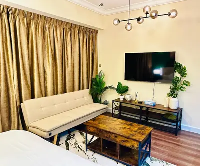 a living room with a couch and a tv at Prime Modern Downtown Studio - Boulevard View in Dubai