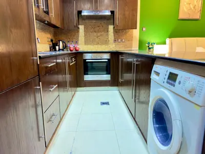 a kitchen with a washing machine in the floor at Prime Modern Downtown Studio - Boulevard View in Dubai
