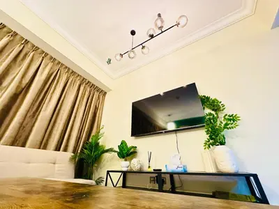 a living room with a couch and a tv on the wall at Prime Modern Downtown Studio - Boulevard View in Dubai