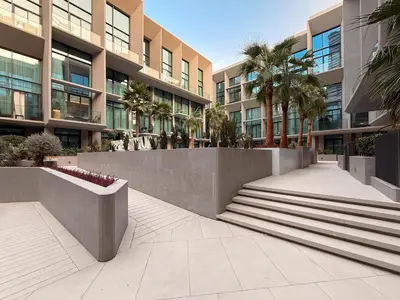 a walkway in front of a building with palm trees at GuestReady | Stylish 1BR Penthouse Retreat in Dubai
