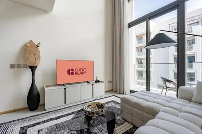 a living room with a couch and a tv at GuestReady | Stylish 1BR Penthouse Retreat in Dubai