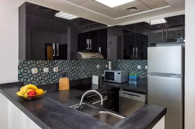 a kitchen with a sink and a refrigerator at VayK - Amazing 1BR in Marina with Sea View in Dubai