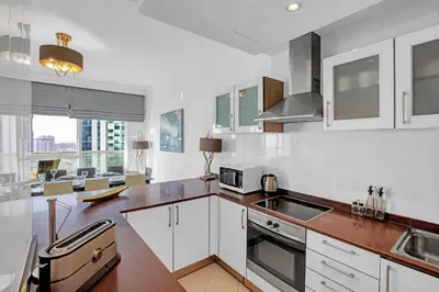 a kitchen with white cabinets and a counter top at VayK - Modern 4BR in Dubai Marina with Sea View in Dubai