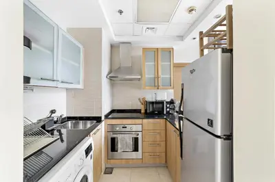 a kitchen with a stainless steel refrigerator and a sink at VayK - Modern and Central 1BR in the Marina in Dubai