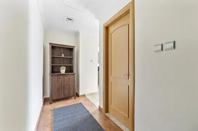 a hallway with a wooden door and a rug at VayK - Modern and Central 1BR in the Marina in Dubai