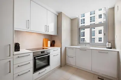 a kitchen with white cabinets and a sink and a window at VayK - Renovated 1BR in Dubai Marina in Dubai