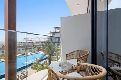 a balcony with a table and chairs and a pool at VayK - Cozy Studio with a Balcony & Pool Views in Dubai