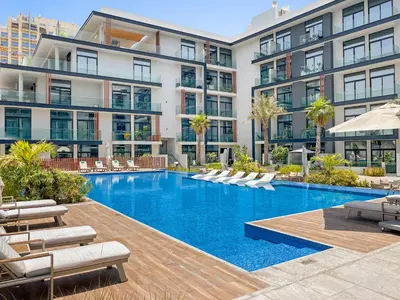 an image of a swimming pool in front of a building at VayK - Cozy Studio with a Balcony & Pool Views in Dubai