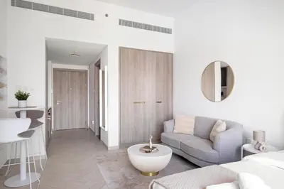 a white room with a bed and a couch and a sink at VayK - Cozy Studio with a Balcony & Pool Views in Dubai