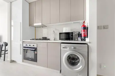 a kitchen with a washer and a washing machine at VayK - Modern Studio in Prime Meydan Area in Dubai