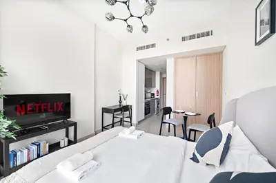a bedroom with a bed and a dining room at VayK - Modern Studio in Prime Meydan Area in Dubai