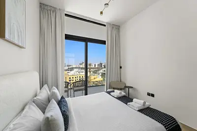 a bedroom with a bed and a large window at VayK - Amazing 1BR in Jvc in Dubai