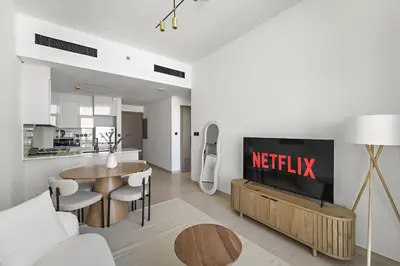 a living room with a television and a kitchen at VayK - Amazing 1BR in Jvc in Dubai
