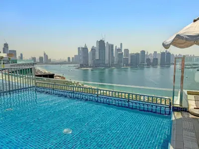 a swimming pool on top of a building with a view of a city at VayK - Great 1BR with Beach Access in Dubai