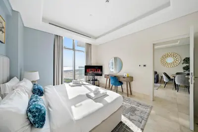 a bedroom with a white bed and a living room at Upscale 1BR with Beach Access on Palm Jumeirah in Dubai