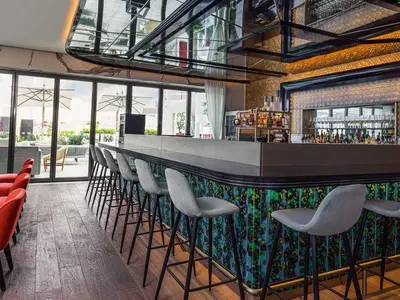 a bar with a row of stools in a restaurant at Upscale 1BR with Beach Access on Palm Jumeirah in Dubai