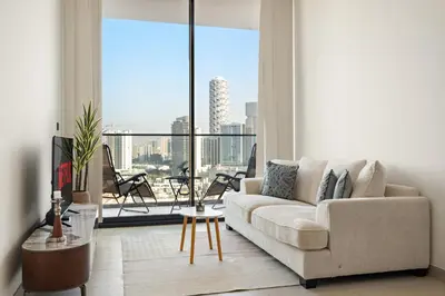 a living room with a couch and a large window at VayK - Heavenly Brand New 1BR in Jvc in Dubai