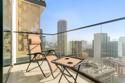 a chair on a balcony with a view of the city at VayK - Heavenly Brand New 1BR in Jvc in Dubai