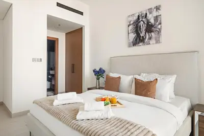 a large white bed with a tray of fruit on it at VayK - Heavenly Brand New 1BR in Jvc in Dubai