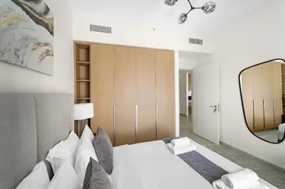 a bedroom with a bed and a large mirror at VayK - Modern 1BR Getaway in Creek Harbour in Dubai