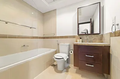a bathroom with a tub and a toilet and a sink at VayK - Modern 1BR in Downtown Dubai in Dubai