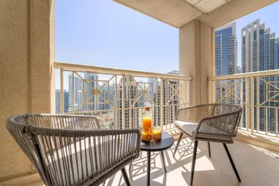 a balcony with two chairs and a table with a drink on it at VayK - Modern 1BR in Downtown Dubai in Dubai