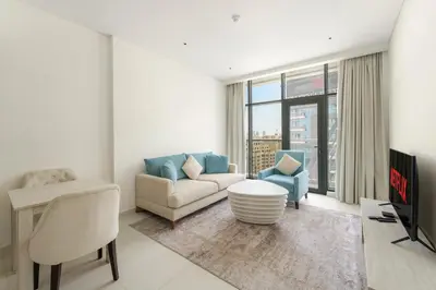 a living room with a couch and a tv at VayK - Modern 1BR on Palm Jumeirah in Dubai