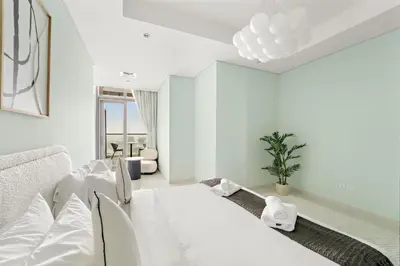 a white room with a bed and a couch at VayK - Spacious 2BR Inside Hotel in Dubai