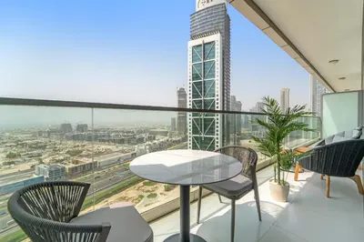a balcony with a table and chairs and a view of a city at VayK - Spacious 2BR Inside Hotel in Dubai