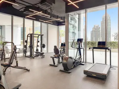 a gym with cardio equipment in a building with windows at VayK - Elegant 2BR with Luxury Amenities in LIV Marina in Dubai