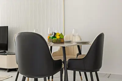 a dining room table with chairs and a bowl of fruit at VayK - Spacious 2BR with Private Pool in Science Park in Dubai
